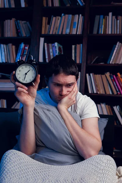 Retrato de hombre con insomnio sentado en la cama con despertador —  Fotos de Stock