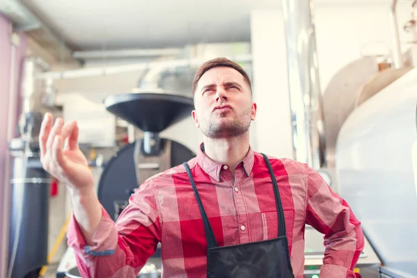 Imagen de hombre barista feliz en delantal sobre fondo de molinillo de café industrial — Foto de Stock