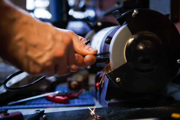 Photo of man sharpening tool — Stock Photo, Image