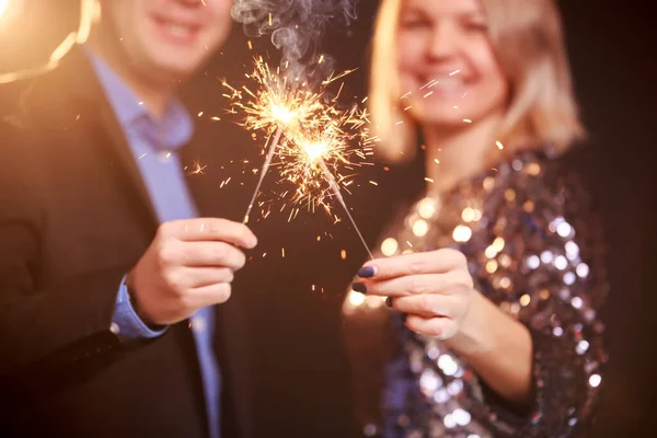 Image de couple heureux avec des étincelles sur fond noir — Photo