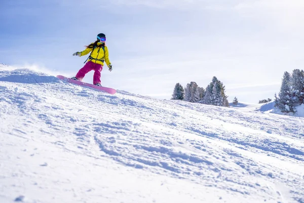겨울 리조트에서 헬멧 스노보드를 타고 있는 운동 선수 여자. — 스톡 사진