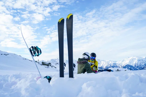 Image de skis, bâtons de ski sur fond de deux femmes sportives avec thermos assis dans la station de ski en hiver . — Photo