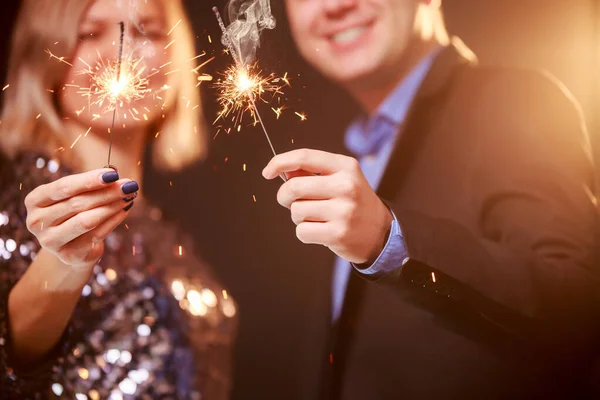 Image d'un jeune couple heureux avec des étincelles sur fond noir — Photo