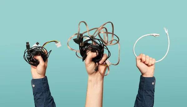 Três mãos com fios velhos. Conceito de resíduos eléctricos . — Fotografia de Stock