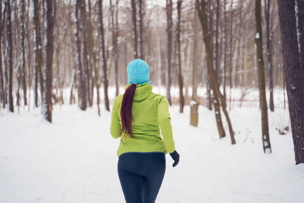 Fénykép hátán fiatal sportoló lány fut a téli parkban — Stock Fotó