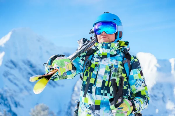 Photo of sports man in helmet and mountain skis against background of mountains. — Φωτογραφία Αρχείου