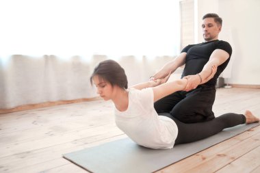 Erkek ve kadın spor salonunun arka planında esneme eğitiminde.