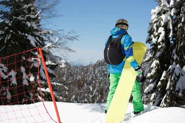Immagine da dietro di uomo di sport con snowboard a resort di montagna . — Foto Stock