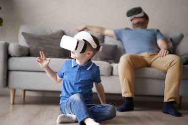 Dairesinde sanal gerçeklik gözlüklü bir erkek ve oğul.