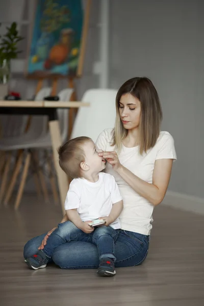 Mamá e hijo pequeño sentados en el piso en el apartamento — Foto de Stock