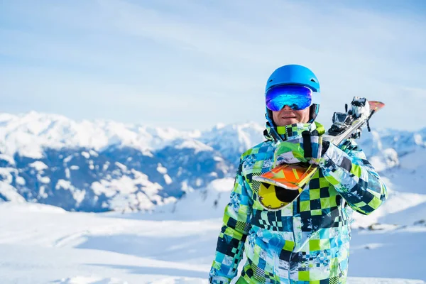 雪のリゾートに立ってスノーボードとヘルメットの幸せなスポーツマンの肖像画 . — ストック写真