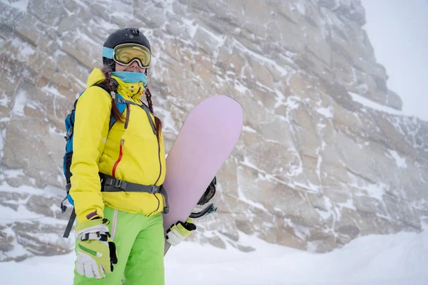 Sportlerin mit Helm und Brille mit Snowboard im Skigebiet . — Stockfoto