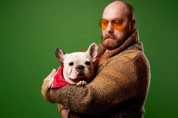 Man in glasses with french bulldog in his arms