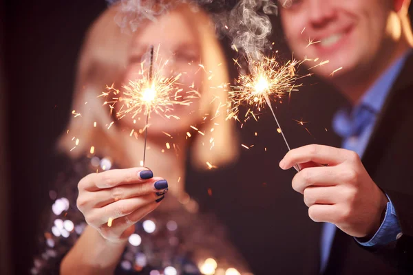 Image de couple heureux avec des étincelles sur fond noir — Photo