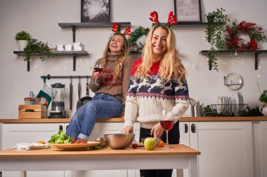 Genç sarışın kadınlar Noel için mutfakta duruyorlar..