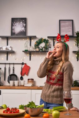 Noel 'de geyik boynuzları takan kadın şarap içer. Yeni yıl kavramı