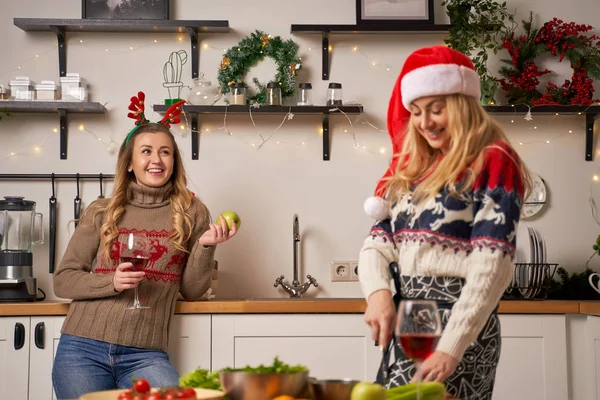 Two blonde girls prepare food for New Year in kitchen — Stockfoto