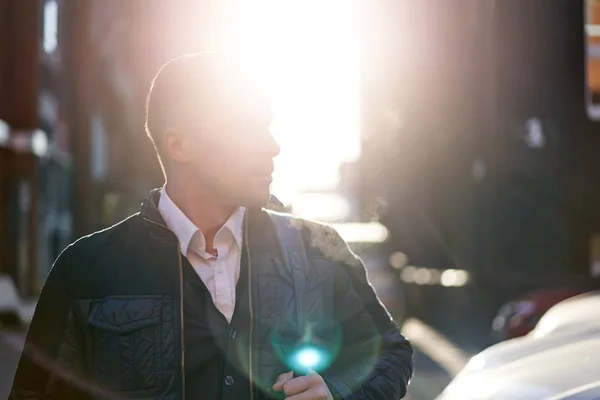 Man looking at side walking in city during day, lensflare effect. — Stockfoto