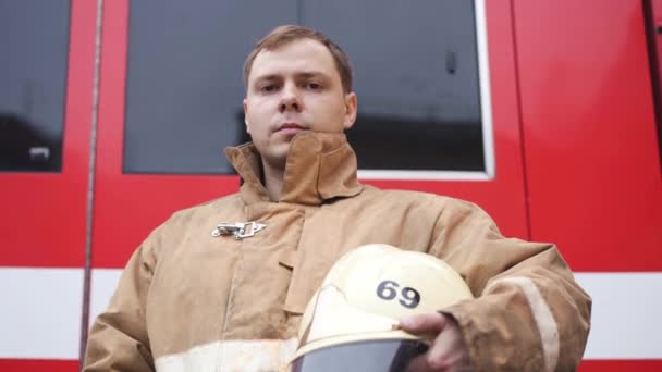 Barna egyenruhás tűzoltó védősisakkal pózol — Stock videók