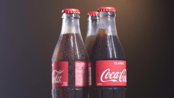 13 de dezembro de 2019. Moscou, Rússia: Três garrafas de vidro de Coca-Cola com gotas frescas na superfície das garrafas. Rotação de vídeo 4k. Conceito sedento — Vídeo de Stock