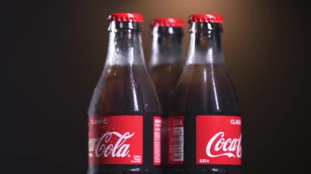 13 december, 2019. Moscow, Russia: Three glass bottles of Coca Cola with fresh drops at bottles surface. 4k video rotation. Thirsty concept — Stock Video