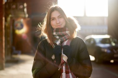 Sonbahar günü şehirde yürüyüş yapan mutlu esmer.
