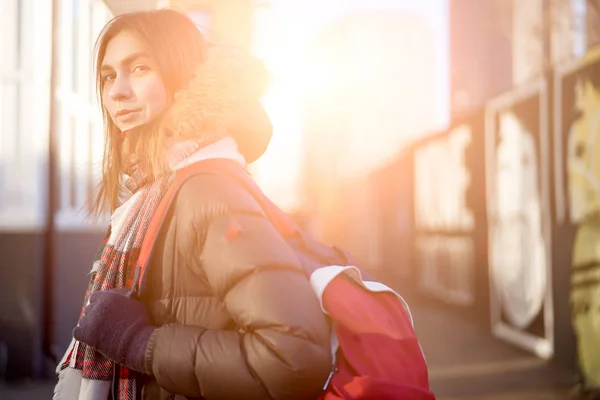 Frau mit rotem Rucksack am Herbsttag in der Stadt unterwegs. — Stockfoto