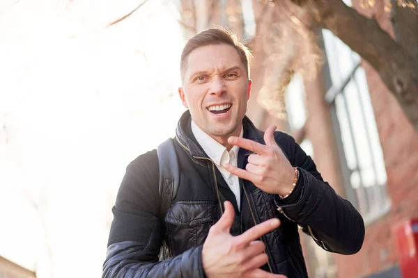 Junger, brünetter Mann spaziert tagsüber durch die Stadt. — Stockfoto