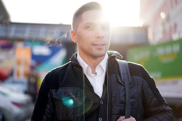 Young man walking in city during day, lensflare effect. — Stock Photo, Image