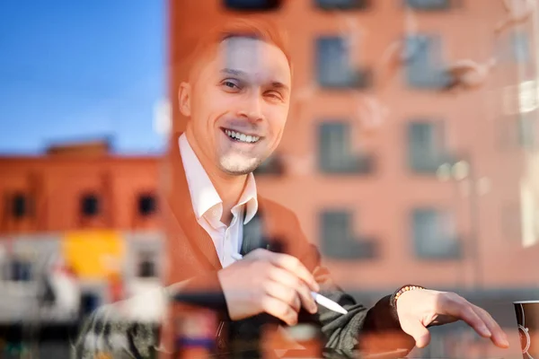 Glückliche männliche Freiberufler mit Telefon und Tablet sitzen im Café und bauen Reflexion — Stockfoto