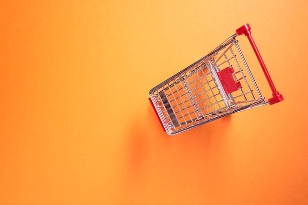 Iron small trolley on empty orange background