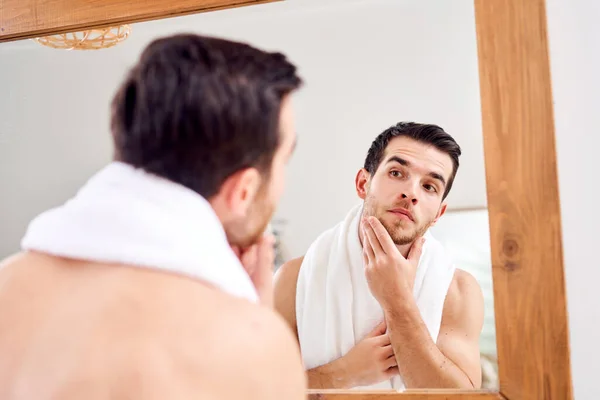 Male with white towel on neck standing near mirror — Stock Photo, Image