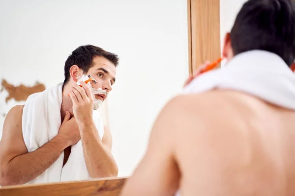 早上，胡子上有泡沫的年轻人在镜子前刮胡子 — 图库照片