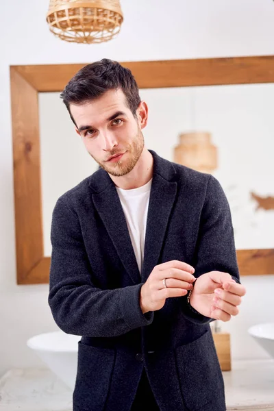 Uomo in giacca nera sta in bagno di fronte specchio — Foto Stock