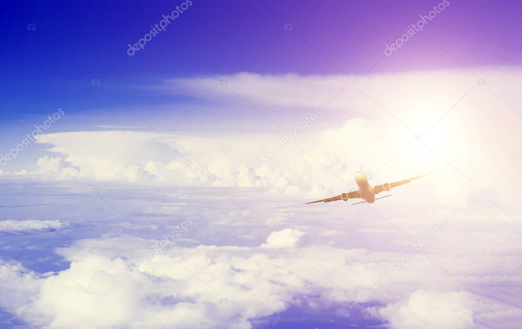 Bottom view in distance of flying airplane in sky among clouds