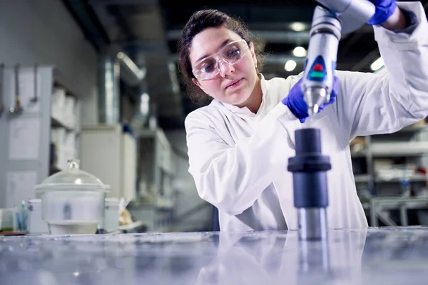 Kvinna laboratorietekniker i blå gummihandskar med 3D-skrivare på defocused bakgrund — Stockfoto