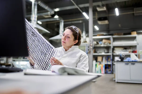 Женщина лаборант сидит за столом с углеродной сеткой — стоковое фото