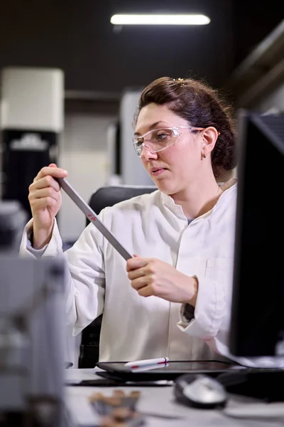 Lab technician girl in white coat sits at table in laboratory — Stock Photo, Image