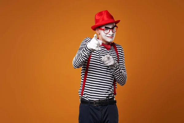 Sérieux mime homme en chapeau rouge et gilet sur fond orange — Photo