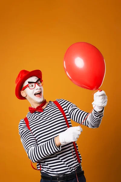 Vidám bohóc pantomim piros labdát narancssárga háttér — Stock Fotó