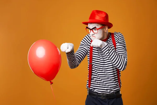 Boze mime met rode bal op oranje achtergrond — Stockfoto