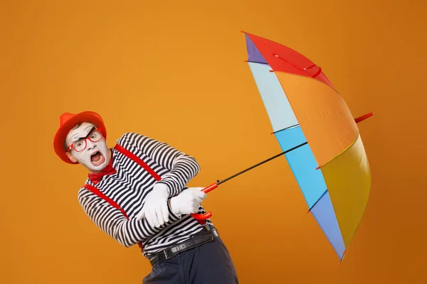 Mime avec parapluie multicolore isolé sur fond blanc orange — Photo