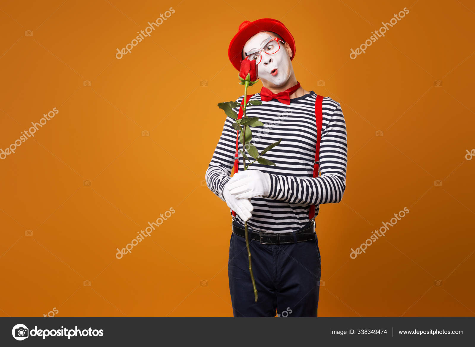 Mimo infeliz con cara blanca en sombrero rojo y camiseta a rayas