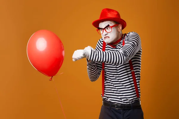 Kwade clown mime box met rode bal op oranje achtergrond — Stockfoto