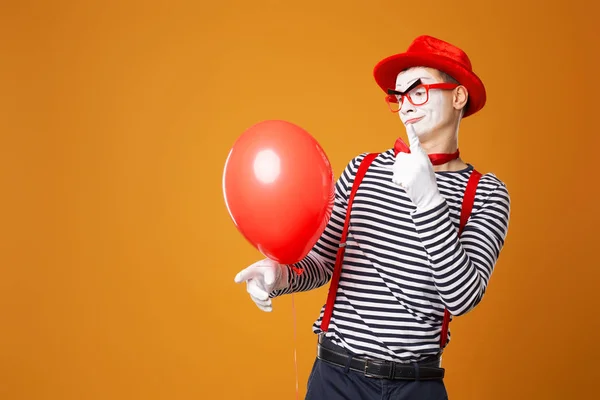 Clown mime met rode bal op oranje achtergrond — Stockfoto