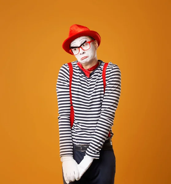 Upset mime man in red hat and vest on orange background — Stock Photo, Image