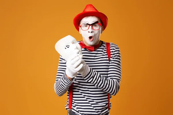 Mime man in red hat and in vest with white mask on orange background — 스톡 사진