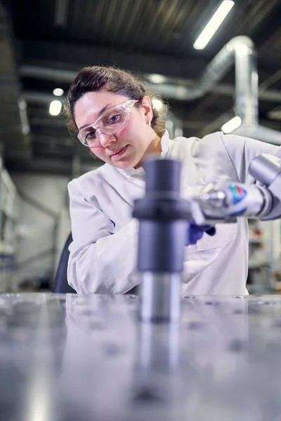 Jeune assistant de laboratoire en manteau blanc avec imprimante 3D sur fond bokeh — Photo