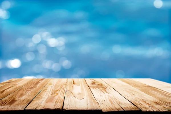 Wooden surface against defocused blue sea background during day — 스톡 사진