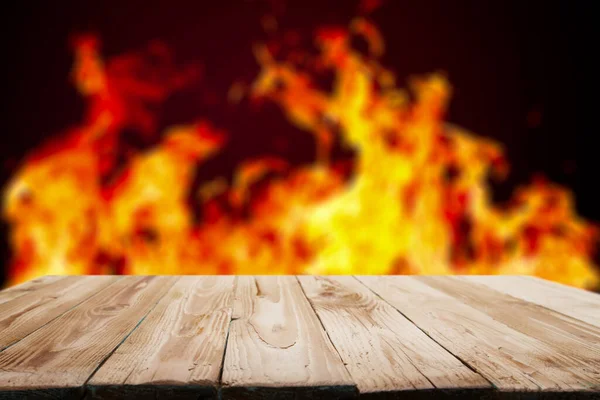 Holzoberfläche vor Hintergrund roter Flammen. — Stockfoto